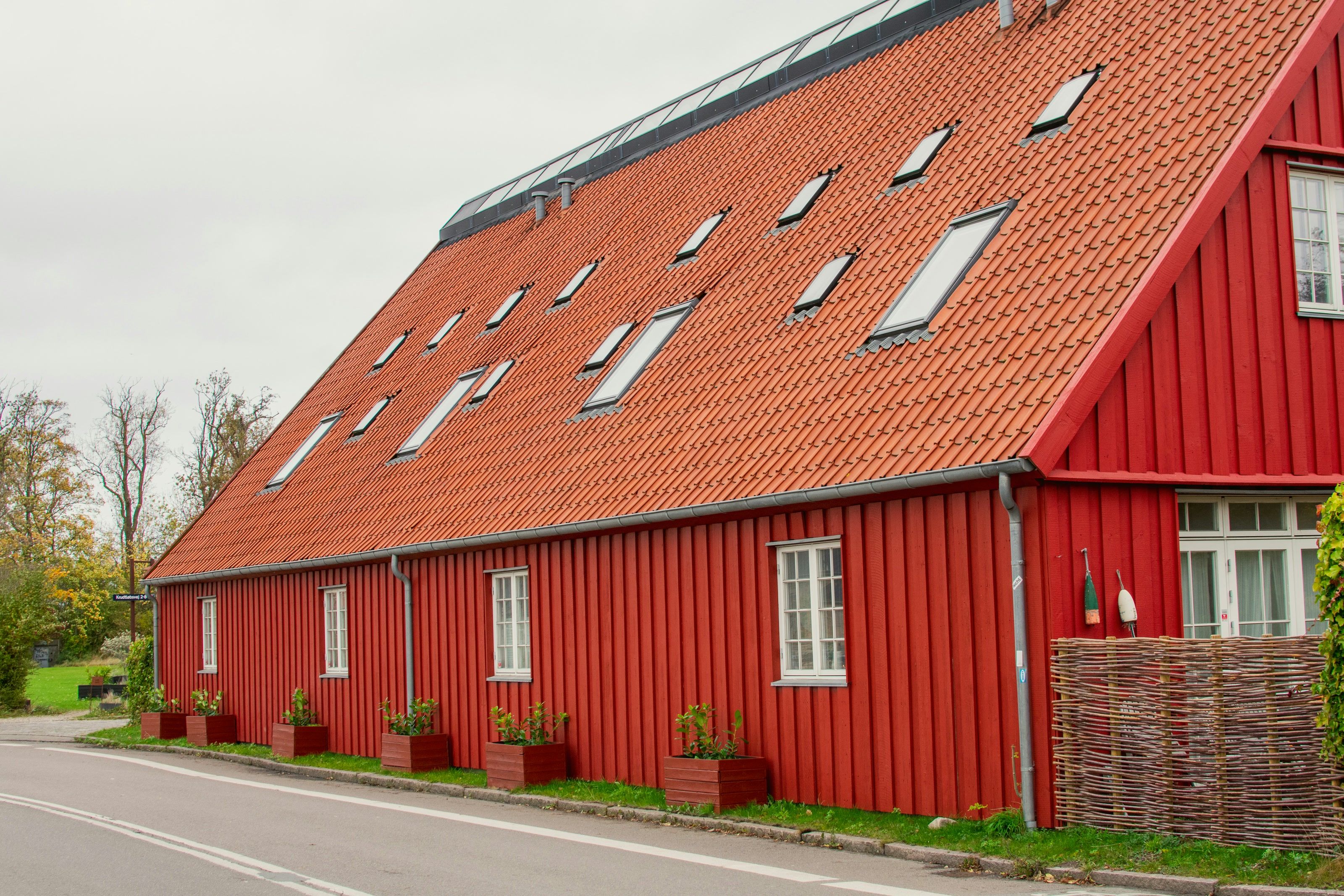 Långt faluröd trähus med nylagt tegeltak och takfönster