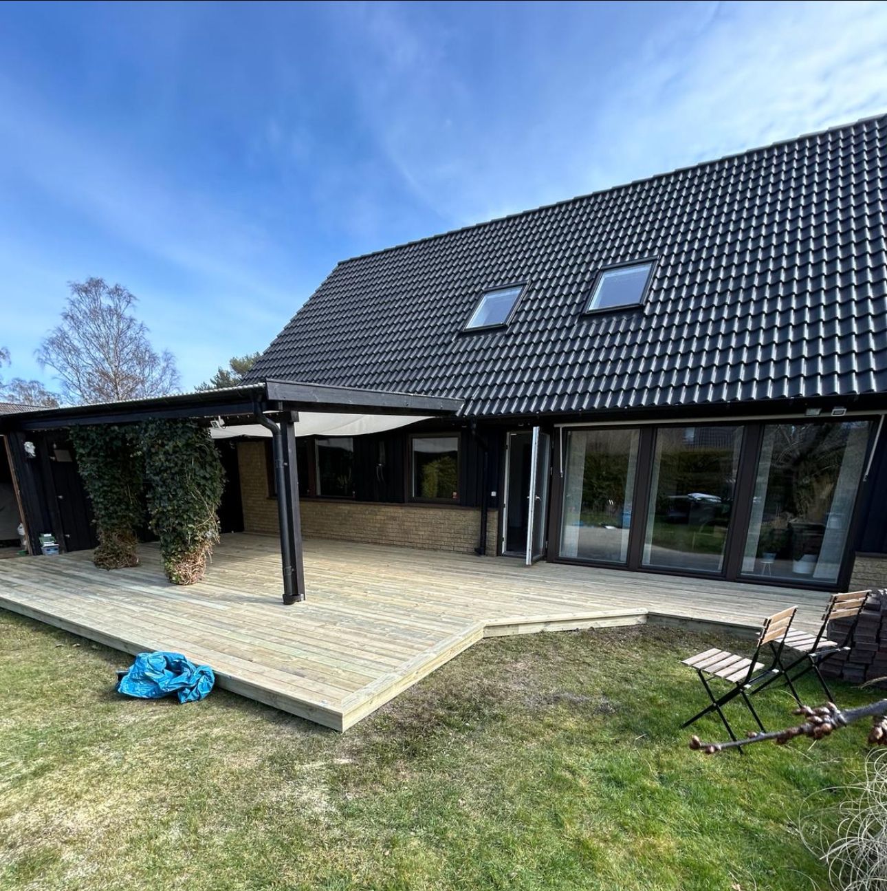 Ny träaltan längs en villa med takfönster